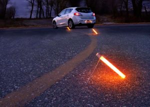 Bâton lumineux Flare Alternative posé au sol pour baliser un aire de stationnement de véhicule en panne